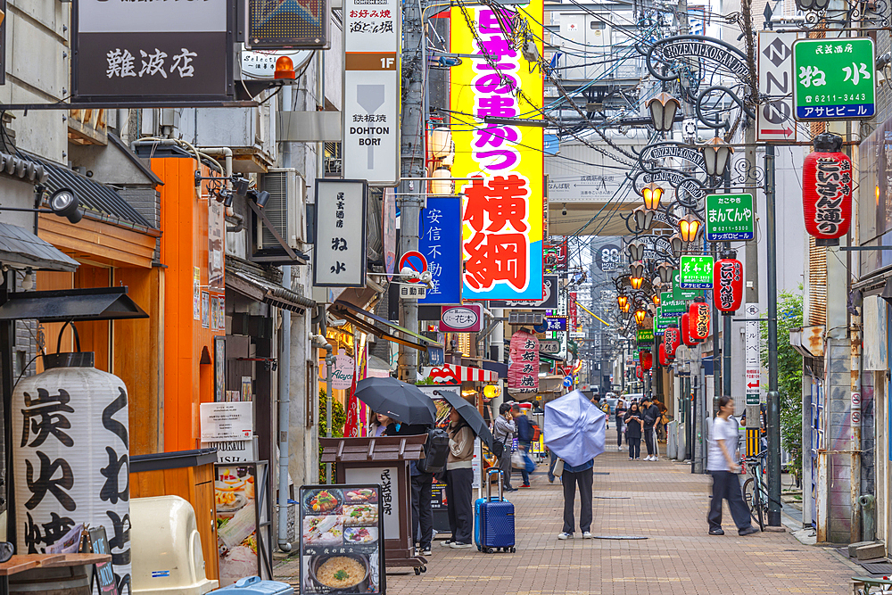 View of colourful signs in backstreet in Dotonbori, vibrant entertainment district near the river, Osaka, Honshu, Japan