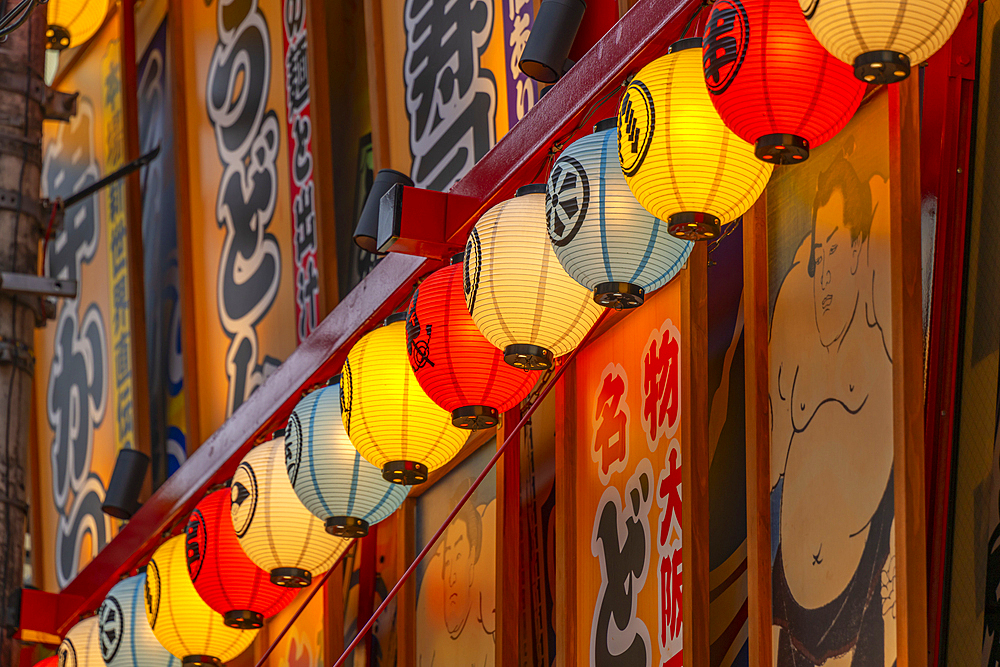 View of colourful facades of shops and restaurants in Dotonbori, vibrant entertainment district near the river, Osaka, Honshu, Japan