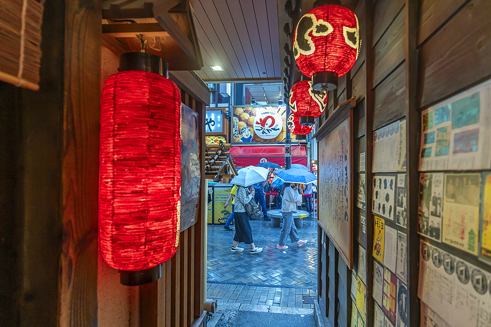 View of Japanese lanterns in dark alleyway in Dotonbori, vibrant entertainment district near the river, Osaka, Honshu, Japan