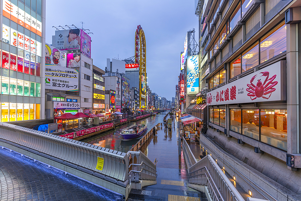 View of colourful adverts in Dotonbori, vibrant entertainment district near the river at dusk, Osaka, Honshu, Japan