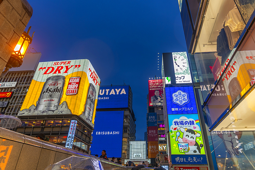 View of colourful adverts in Dotonbori, vibrant entertainment district near the river at dusk, Osaka, Honshu, Japan