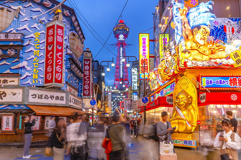 View of Tsutenkaku Tower and restaurants neon lights at dusk in the Shinsekai area, Osaka, Honshu, Japan