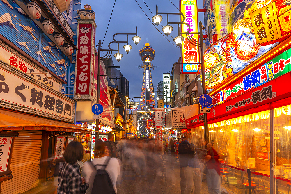 View of Tsutenkaku Tower and restaurants neon lights at dusk in the Shinsekai area, Osaka, Honshu, Japan