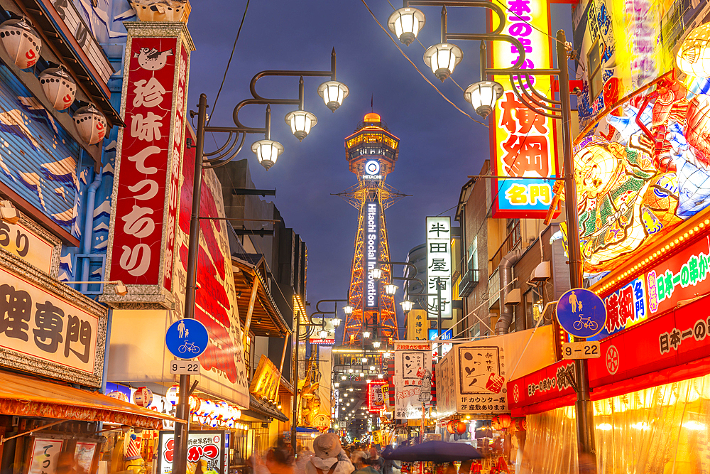 View of Tsutenkaku Tower and restaurants neon lights at dusk in the Shinsekai area, Osaka, Honshu, Japan