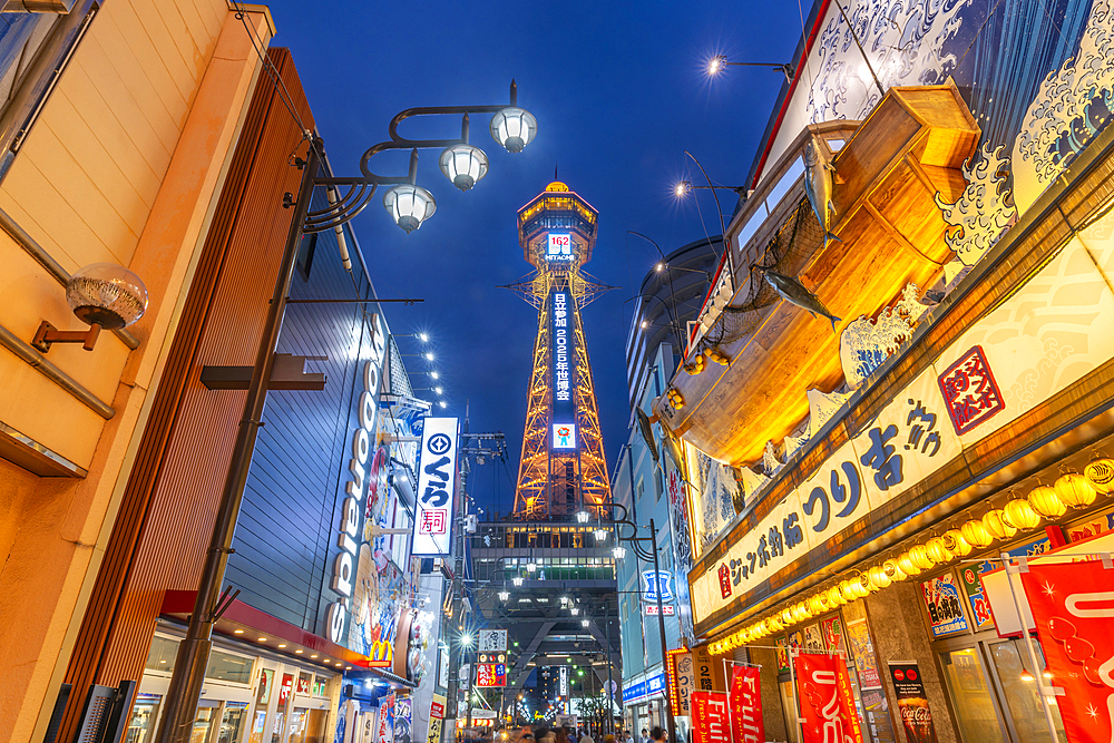 View of Tsutenkaku Tower and restaurants neon lights at dusk in the Shinsekai area, Osaka, Honshu, Japan