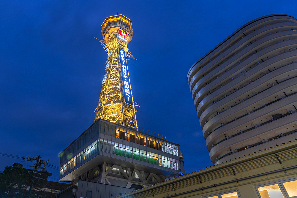 View of Tsutenkaku Tower and restaurants neon lights at dusk in the Shinsekai area, Osaka, Honshu, Japan