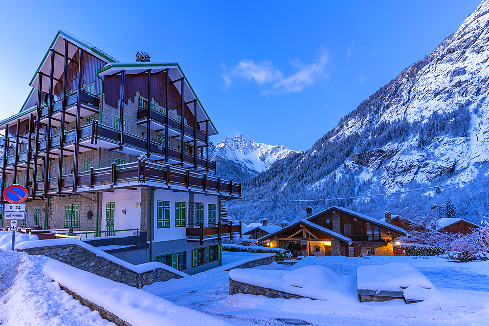 View of chalets and snow covered mountains in Courmayeur before dawn during winter, Courmayeur, Aosta Valley, Italy, Europe