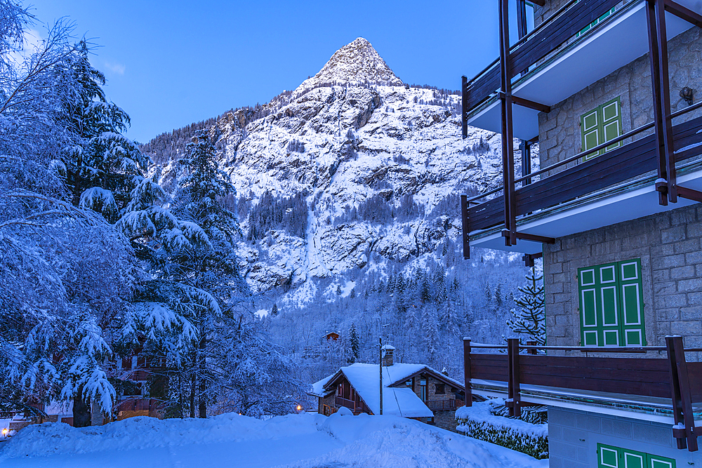 View of chalets and snow covered mountains in Courmayeur before dawn during winter, Courmayeur, Aosta Valley, Italy, Europe