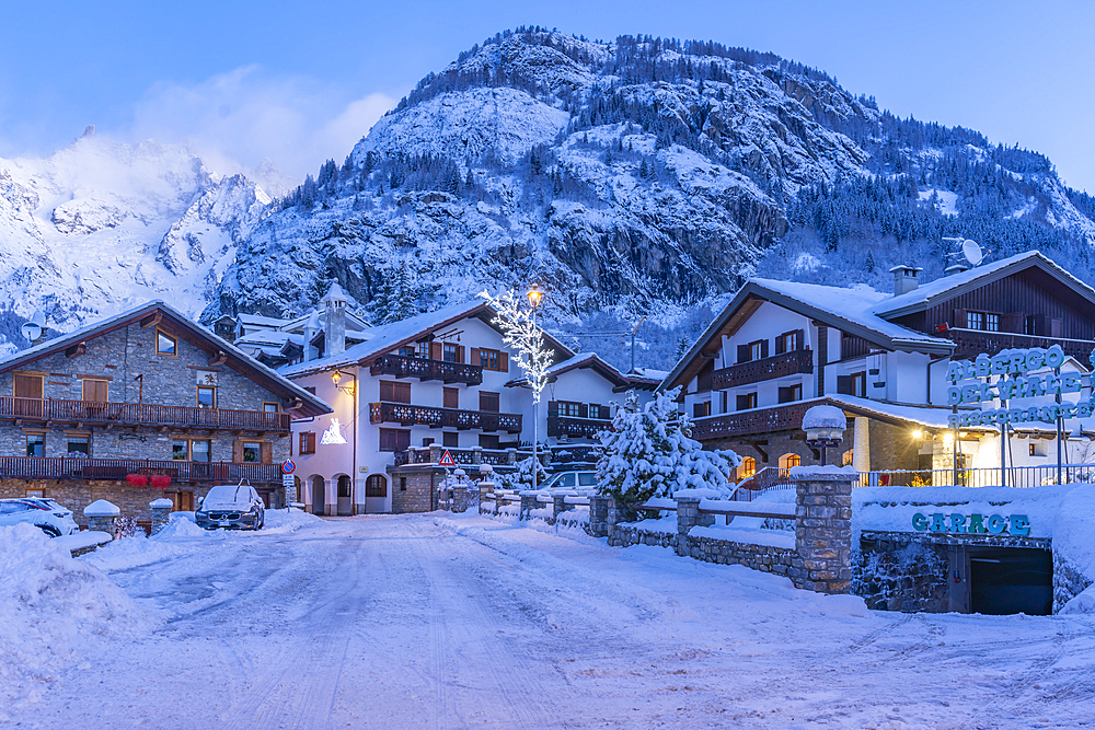 View of chalets and snow covered mountains in Courmayeur before dawn during winter, Courmayeur, Aosta Valley, Italy, Europe