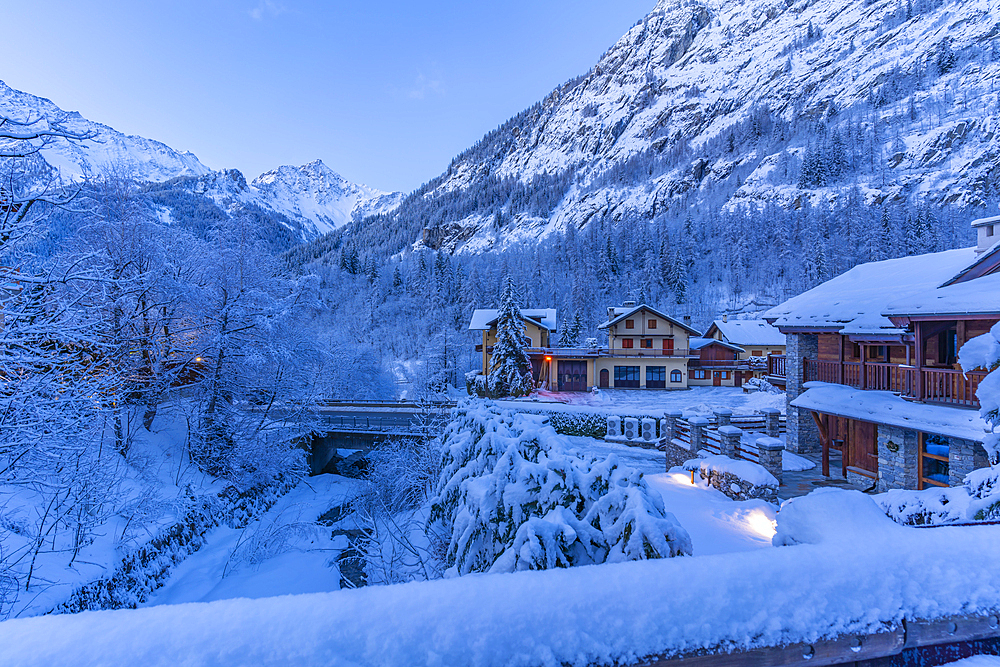 View of chalets and snow covered mountains in Courmayeur before dawn during winter, Courmayeur, Aosta Valley, Italy, Europe