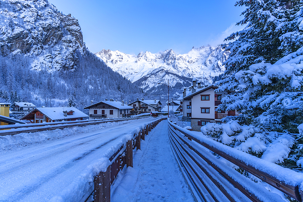 View of chalets and snow covered mountains in Courmayeur before dawn during winter, Courmayeur, Aosta Valley, Italy, Europe