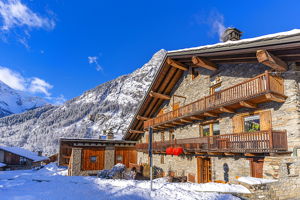 View of chalets and snow covered mountains in Courmayeur at sunrise during winter, Courmayeur, Aosta Valley, Italy, Europe