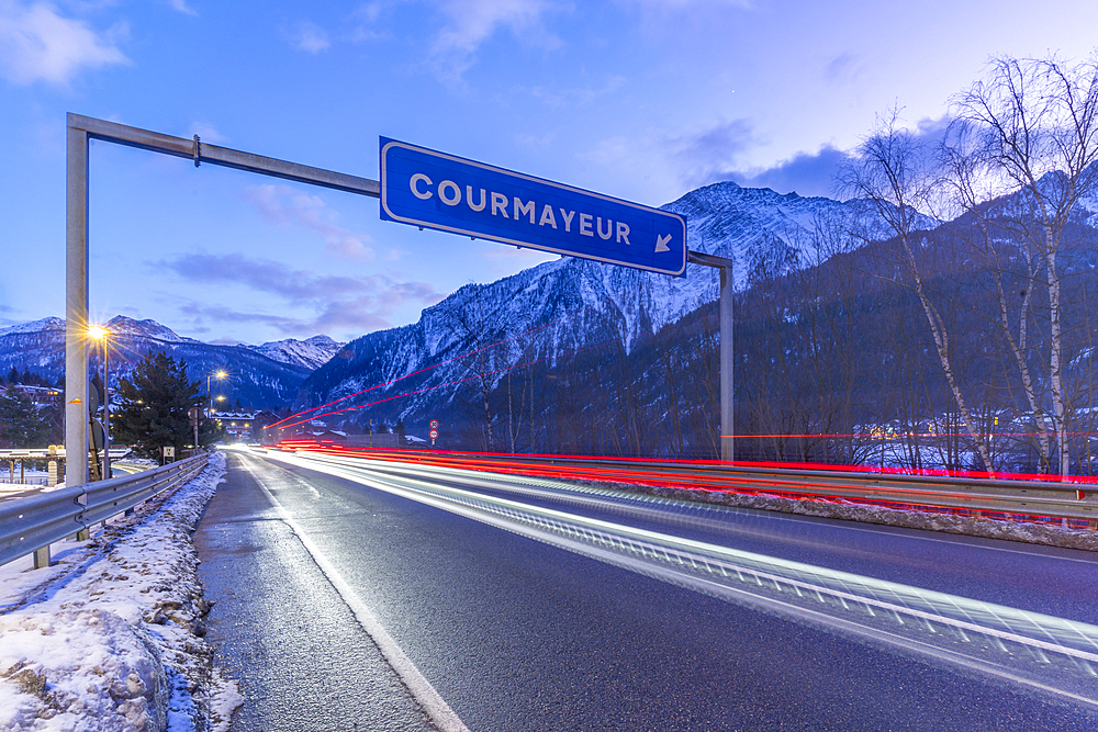 View of snow covered mountains and trail lights in Courmayeur at dusk in winter, Courmayeur, Aosta Valley, Italy, Europe