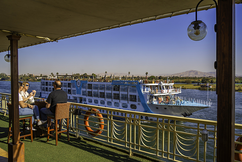 View of scenery and cruise boat from cruise boat near Armant on the Nile River, Luxor, Egypt, Africa