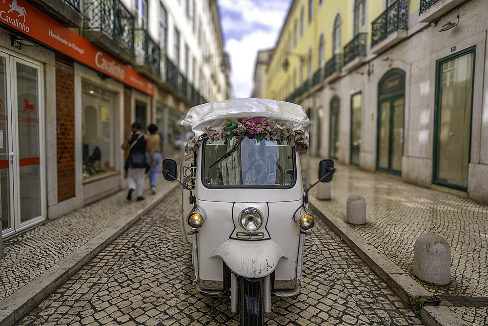 View of Tuk Tuk on cobbled street on a sunny day, Lisbon, Portugal, Europe