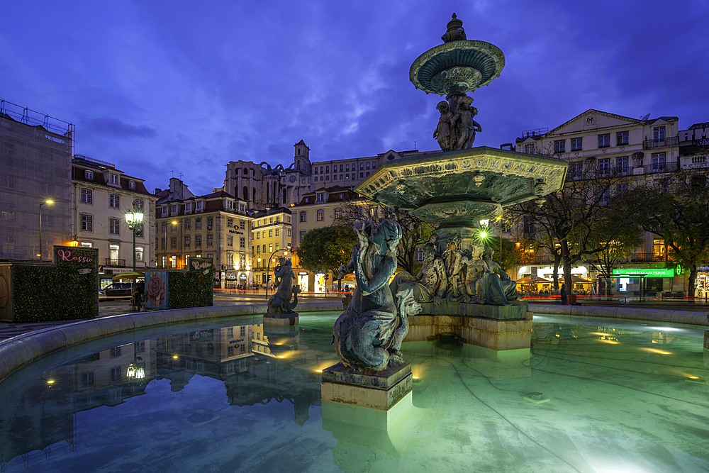 View of South fountain of Rossio in Praca do Rossio at dusk, Lisbon, Portugal, Europe