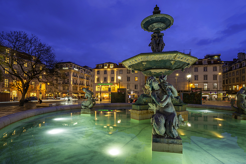 View of South fountain of Rossio in Praca do Rossio at dusk, Lisbon, Portugal, Europe