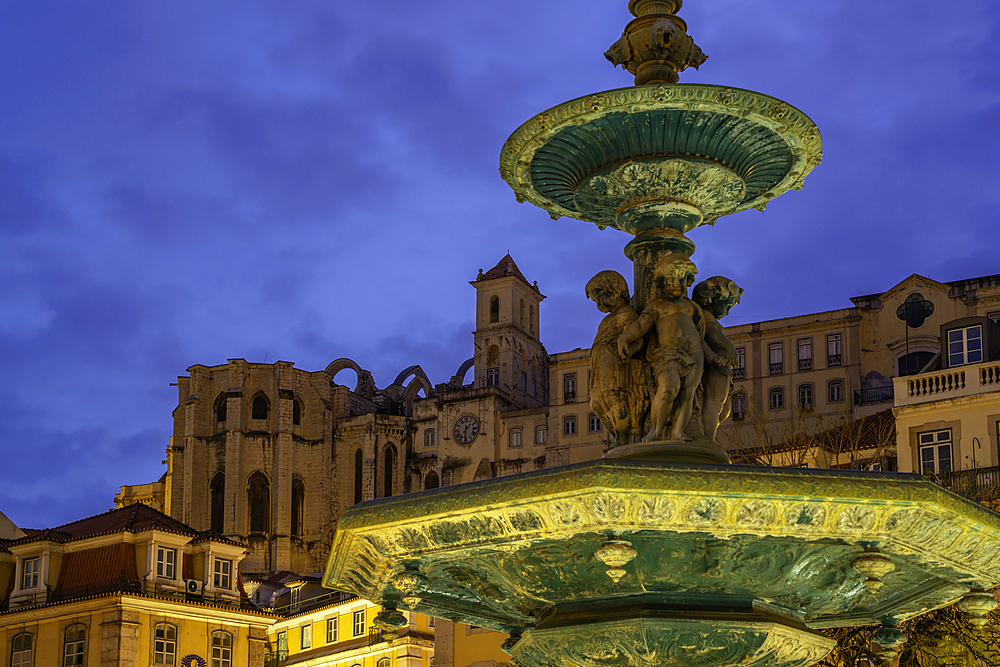 View of South fountain of Rossio in Praca do Rossio and Carmo Archaeological Museum at dusk, Lisbon, Portugal, Europe
