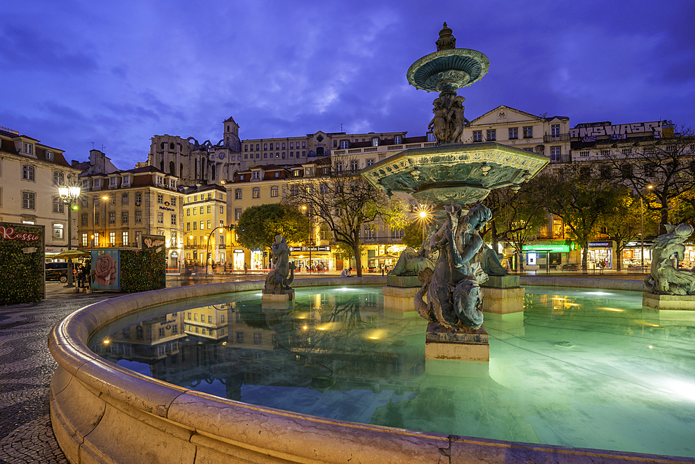 View of South fountain of Rossio in Praca do Rossio at dusk, Lisbon, Portugal, Europe