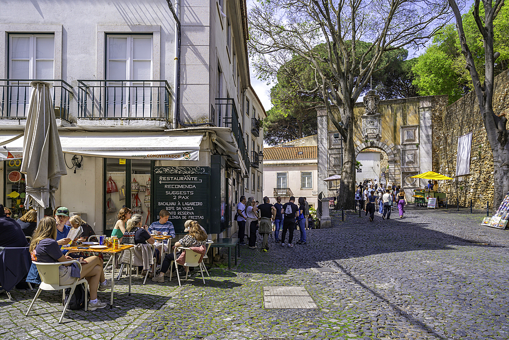 View of cafe and Arco do Castelo, entrance to Lisbon Castle, Alfama District, Lisbon, Portugal, Europe