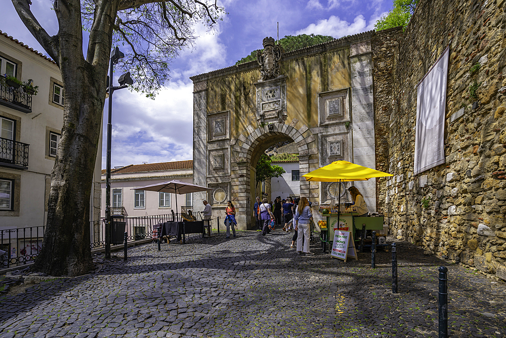 View of stall and Arco do Castelo, entrance to Lisbon Castle, Alfama District, Lisbon, Portugal, Europe