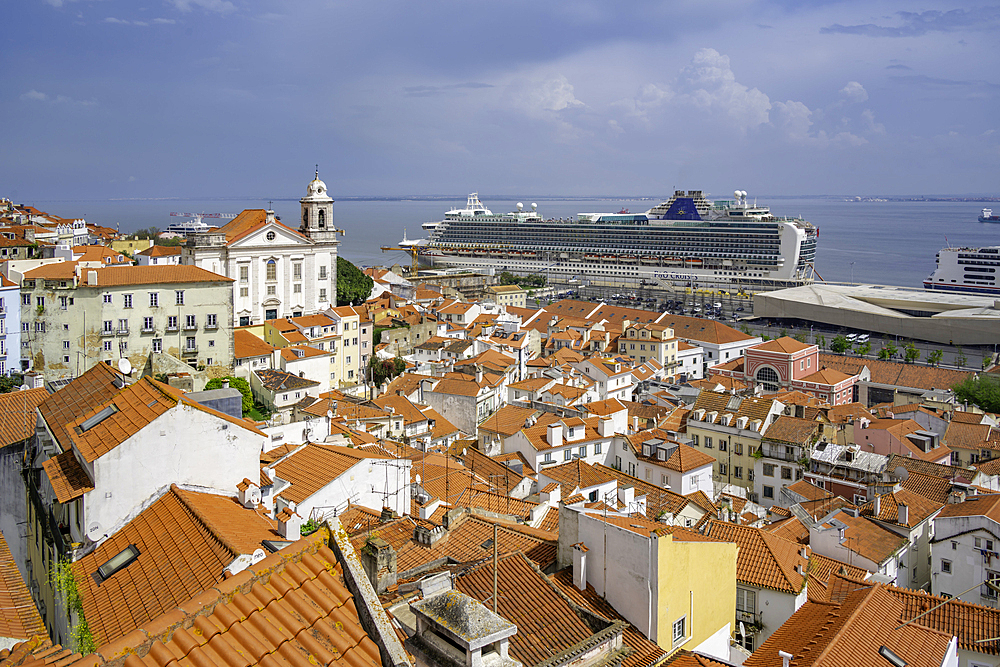 View of cruise ship in port and terrakotta rooftops in Alfama, Alfama District, Lisbon, Portugal, Europe