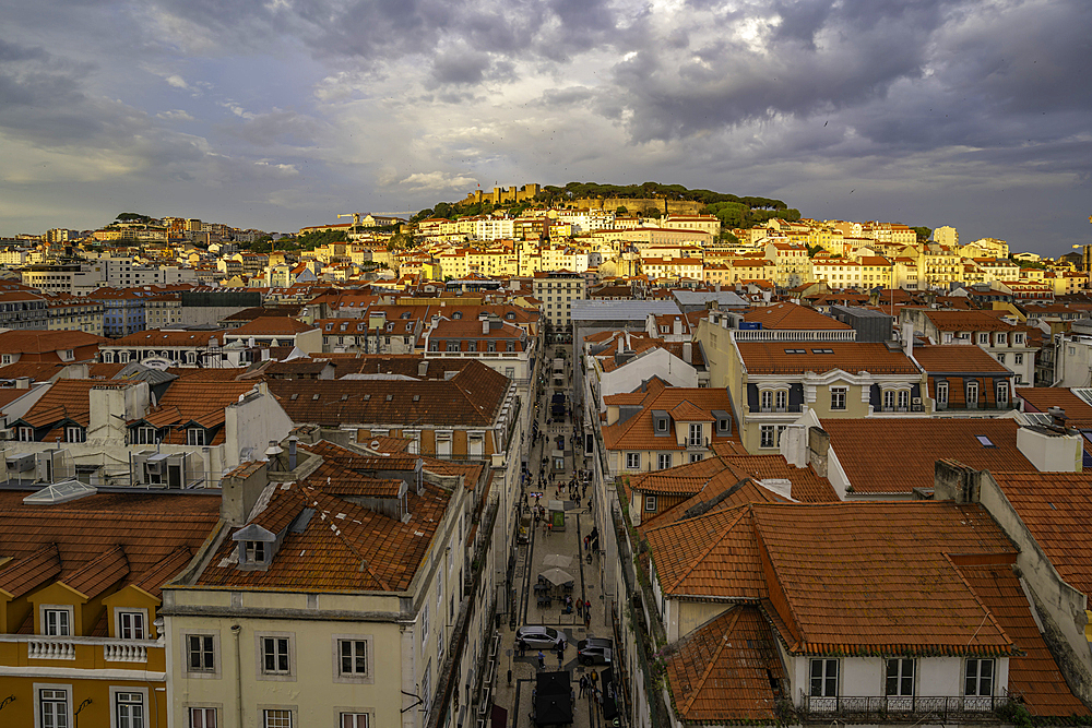 View of city rooftops and Lisbon Castle from Santa Justa Lift during golden hour, Lisbon, Portugal, Europe