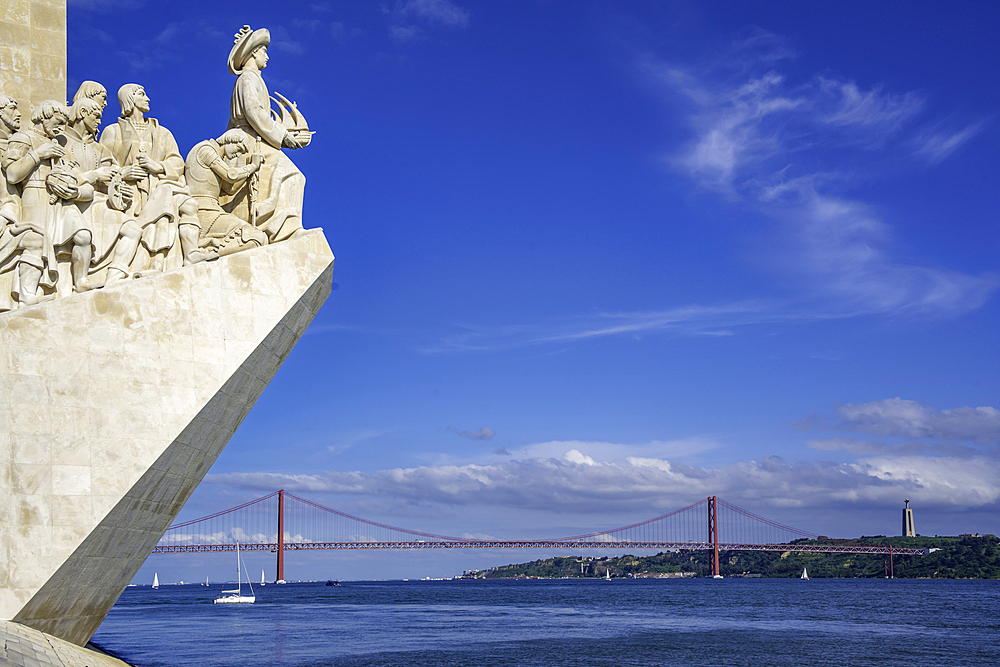 View of Monument to the Discoveries (Padrão dos Descobrimentos) and 25 April Bridge on a sunny day, Lisbon, Portugal, Europe