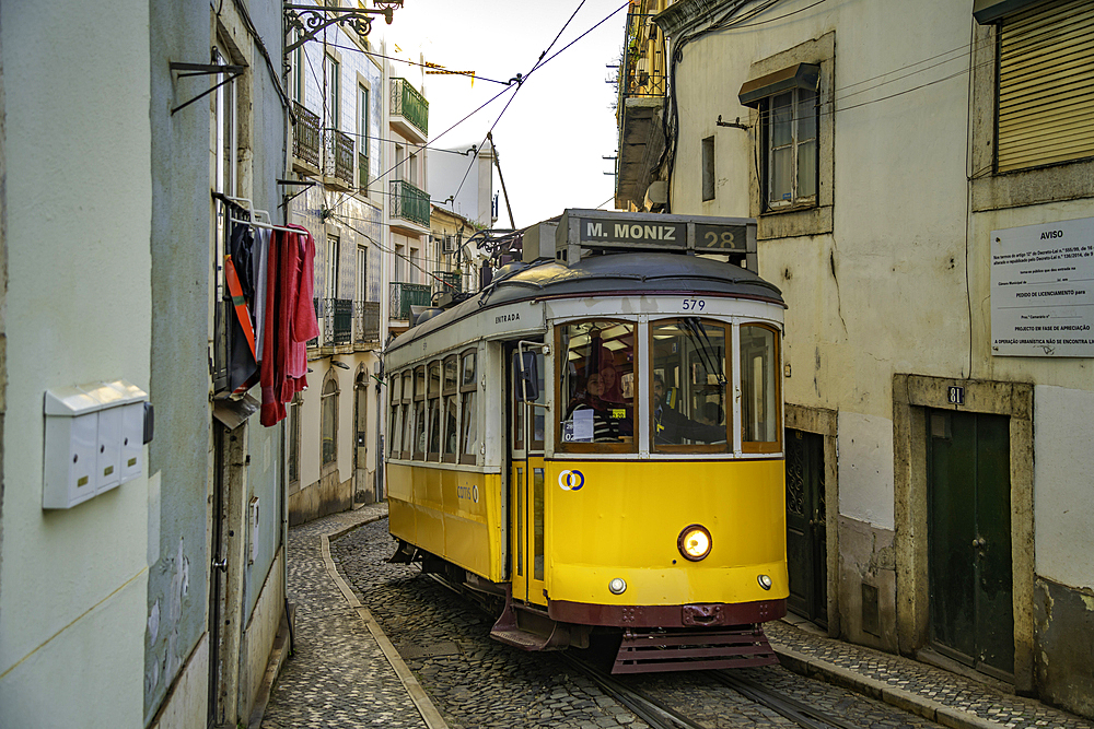 View of vintage tram and colourful buildings in the Alfama District on a sunny day, Lisbon, Portugal, Europe