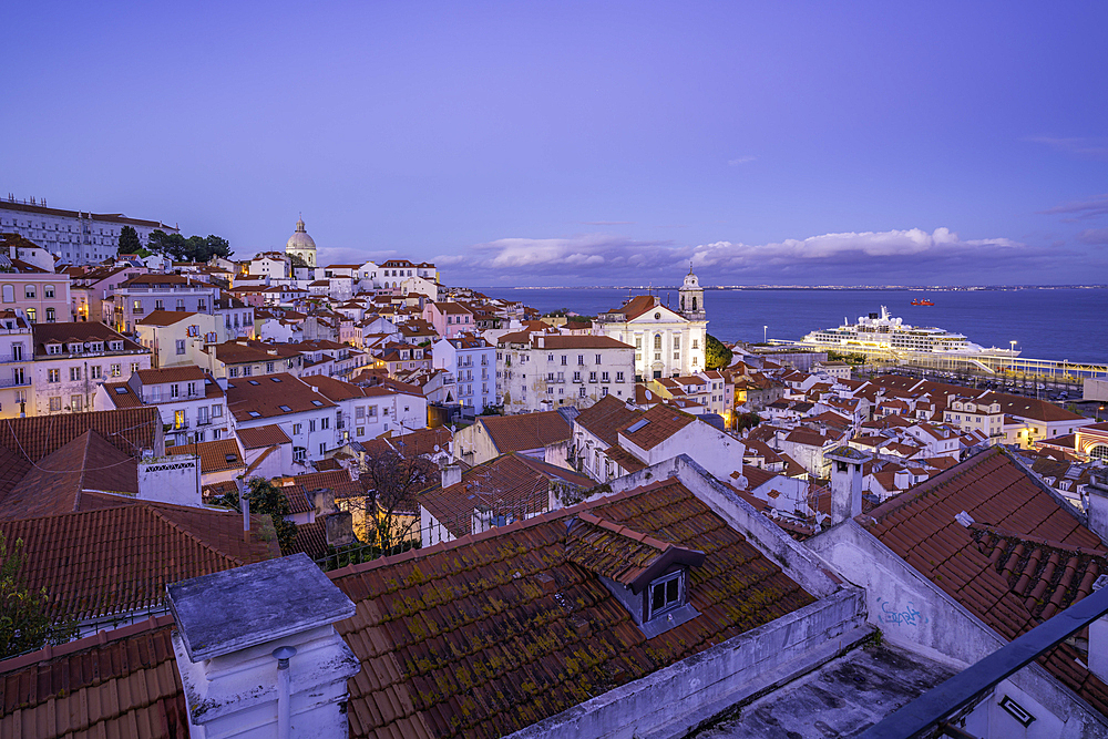 View of colourful buildings and red rooftops at dusk in the Alfama District, Lisbon, Portugal, Europe