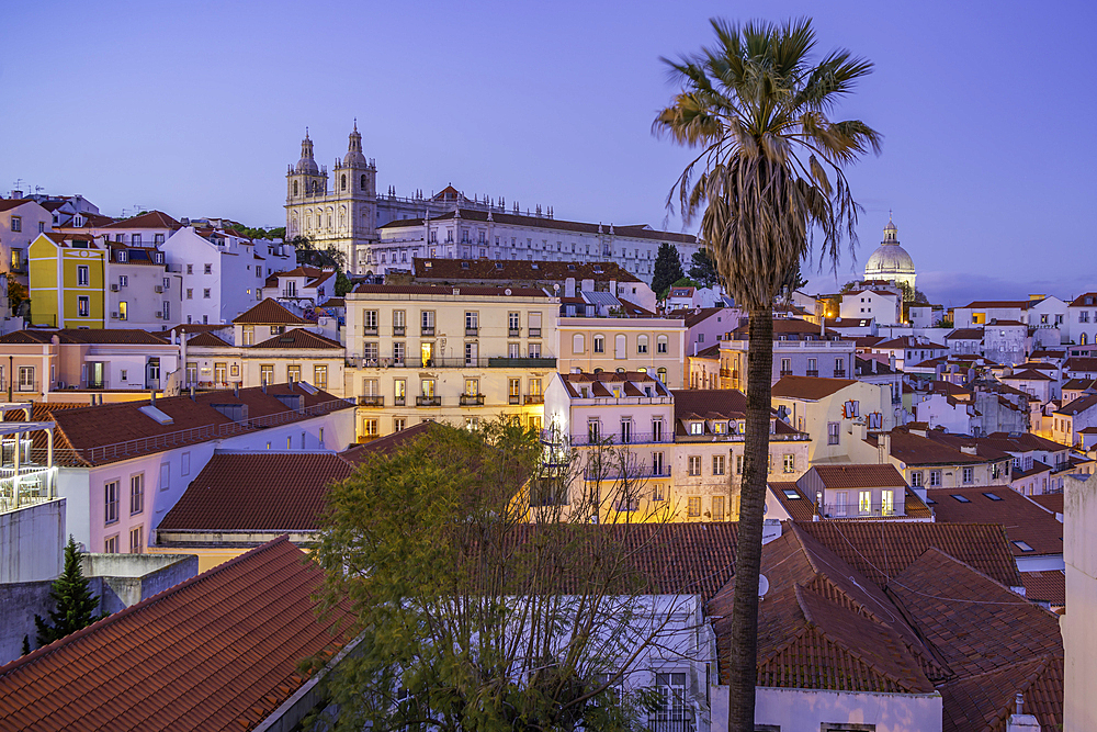 View of colourful buildings and red rooftops at dusk in the Alfama District, Lisbon, Portugal, Europe