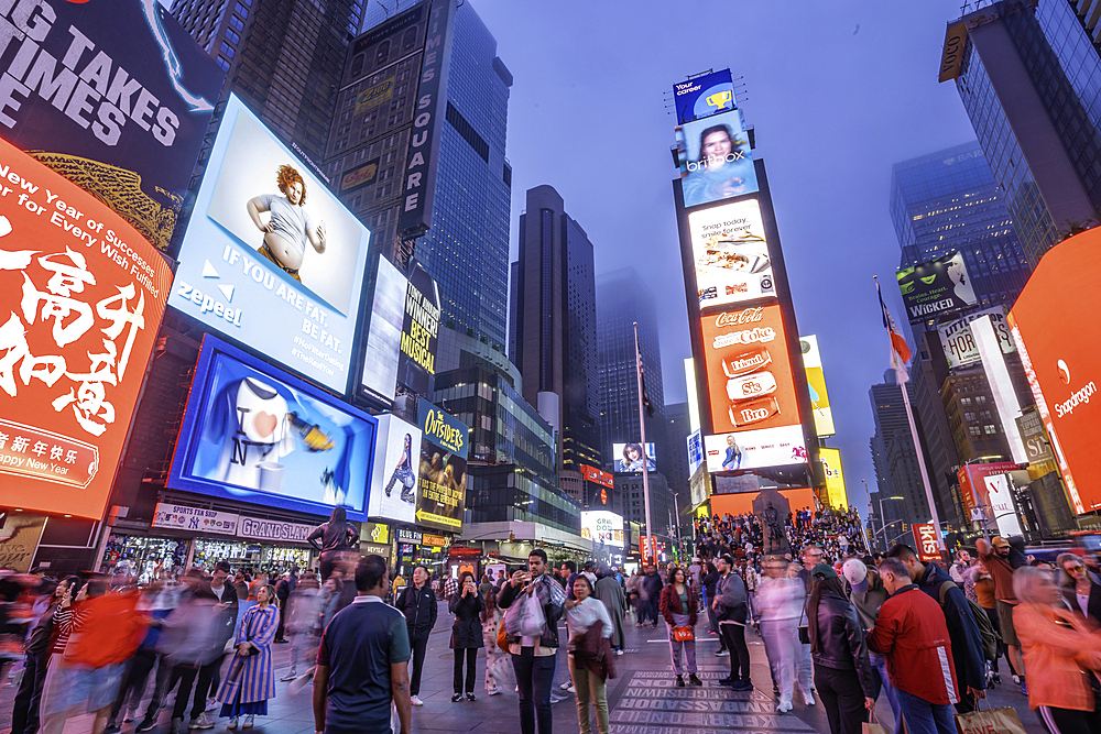 View of neon lights in Times Square at dusk, New York City, United States of America, North America