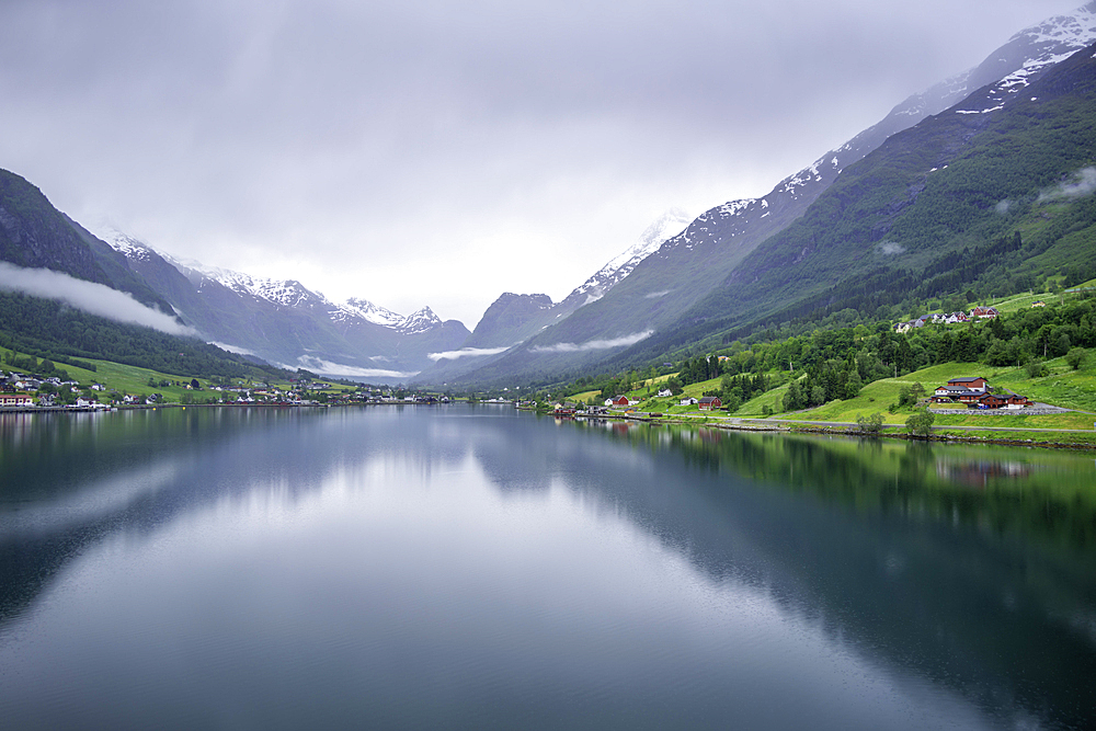 View of Olden village and mountains reflecting in Nordfjorden during summer, Norway, Scandinavia, Europe