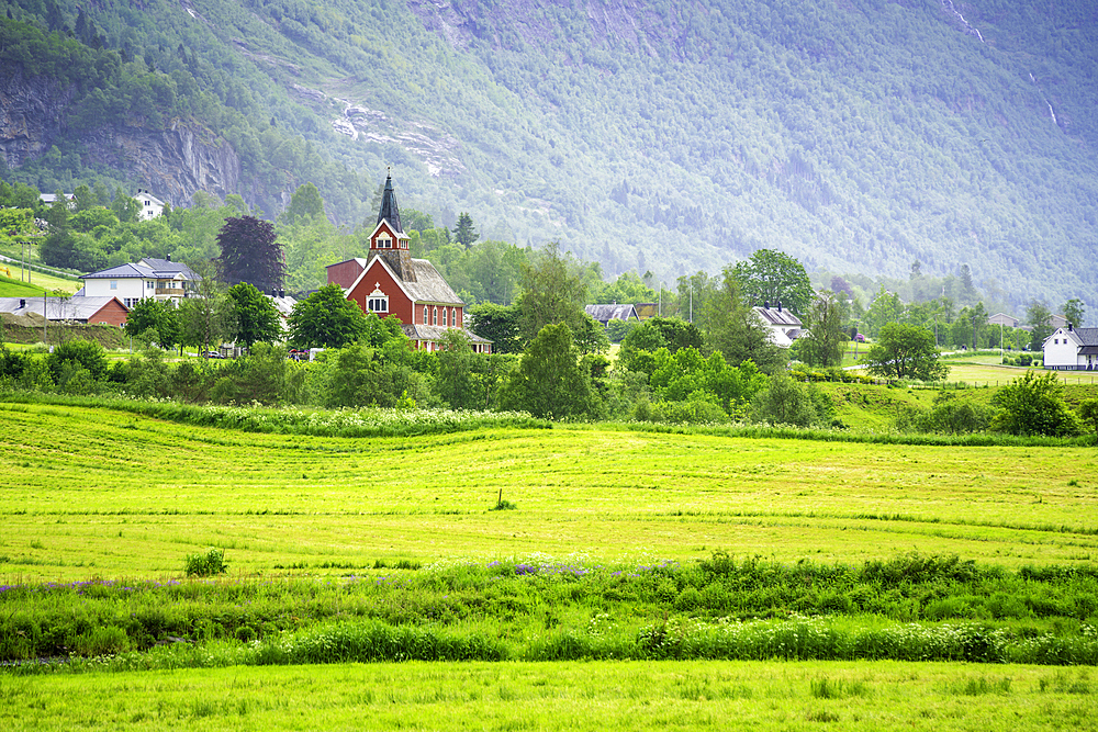 View of Olden New Church in Olden village and mountains in Nordfjorden during summer, Norway, Scandinavia, Europe