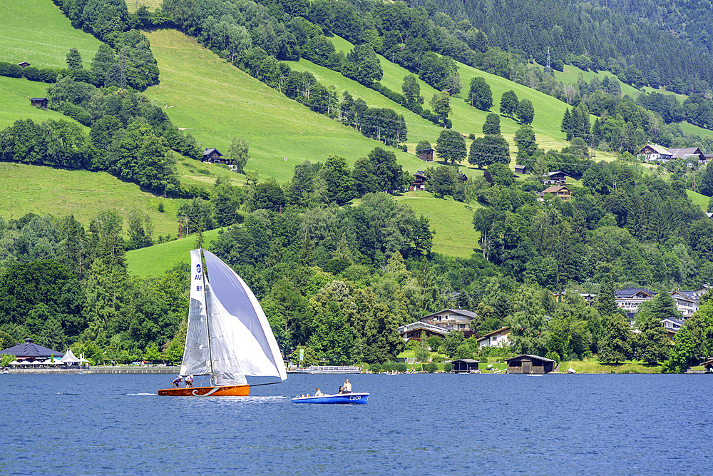 View of boat on Lake Zell from Zell am See and mountainous backdrop on a sunny day, Zell am See, Salzburg, Austria, Europe