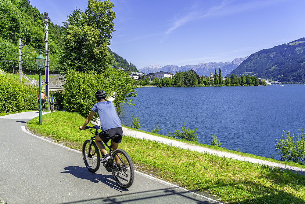 View of cyclist by Lake Zell in Zell am See on a sunny day, Zell am See, Salzburg, Austria, Europe