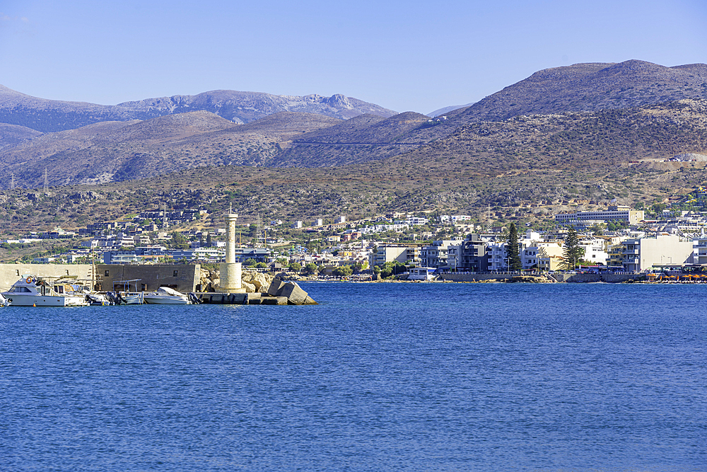 View of lighthouse, coastline and hotels in Limenas Chersonisou, Crete, Greek Islands, Greece, Europe