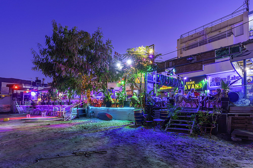 View of taverna and small beach at Port of Limenas Chersonisou at dusk, Limenas Chersonisou, Crete, Greek Islands, Greece, Europe