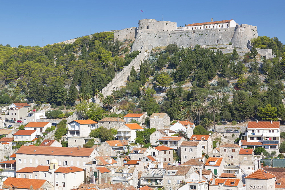 View of Hvar Main Square overlooked by Spanish Fortress, Hvar, Hvar Island, Dalmatia, Croatia, Europe