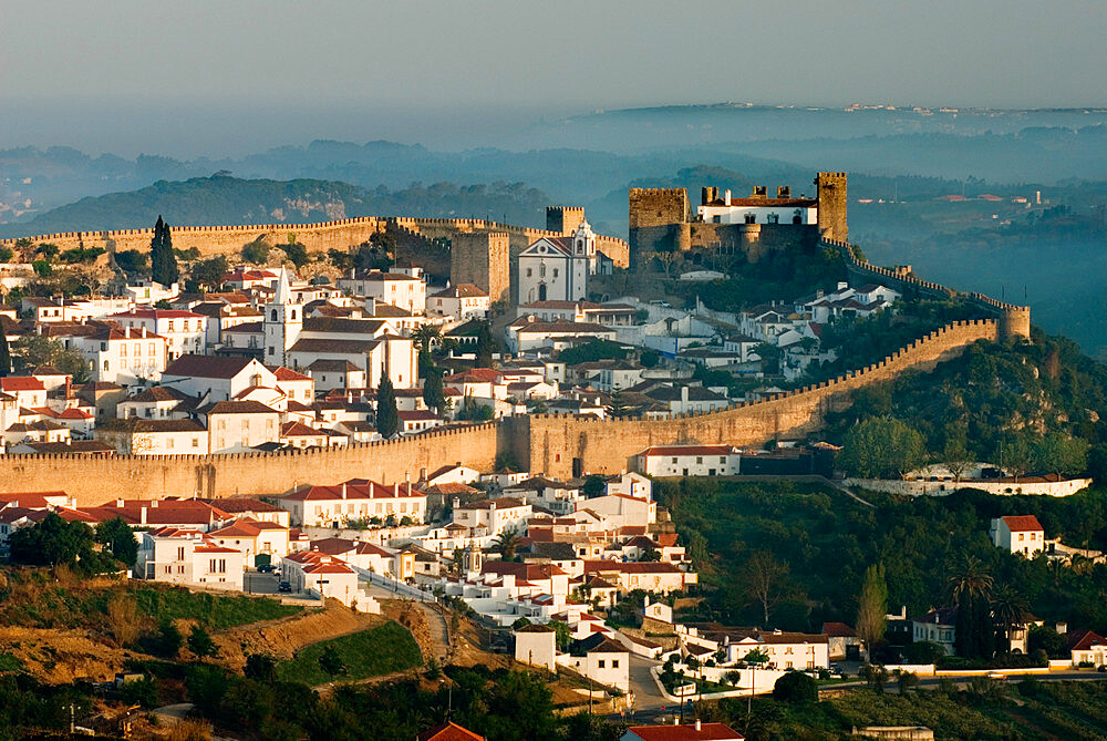 View over old town and castle walls in dawn mist, Obidos, Estremadura, Portugal, Europe