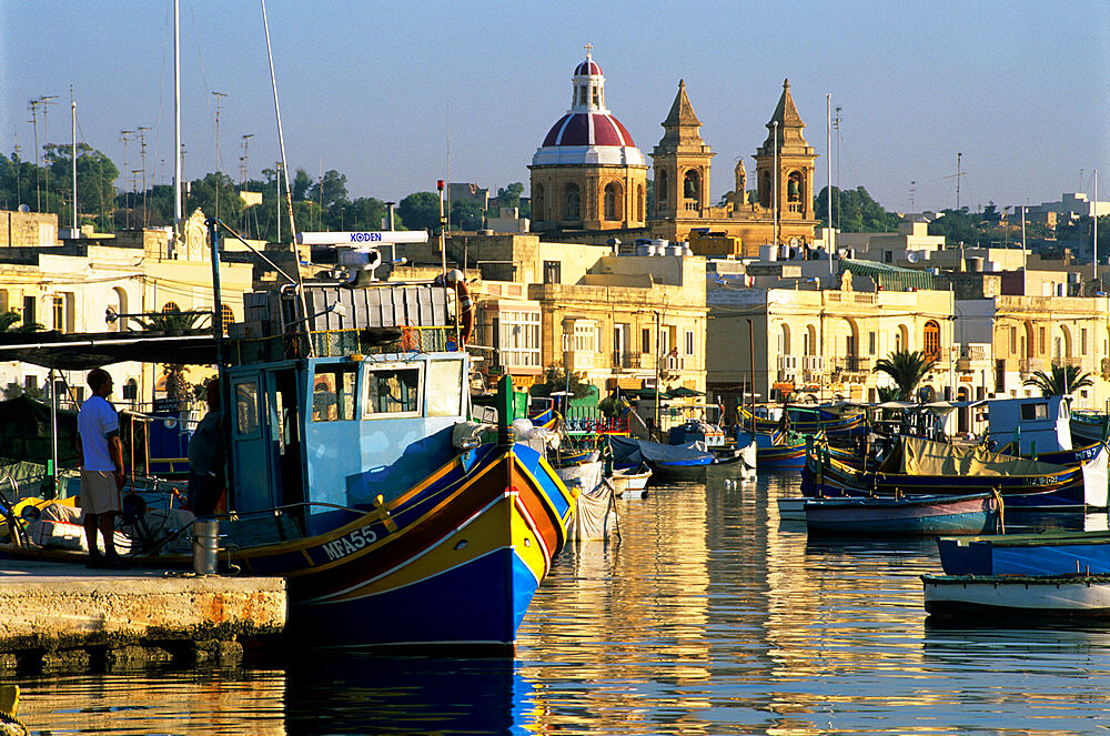 View across harbour with traditional Luzzu fishing boats, Marsaxlokk, Malta, Mediterranean, Europe