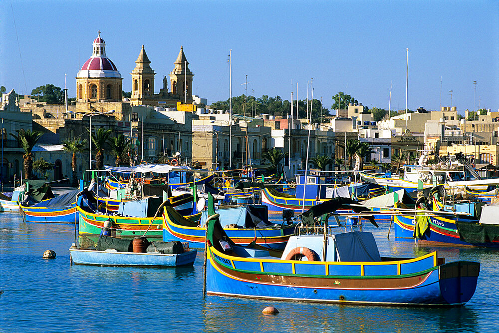 View across harbour with traditional Luzzu fishing boats, Marsaxlokk, Malta, Mediterranean, Europe