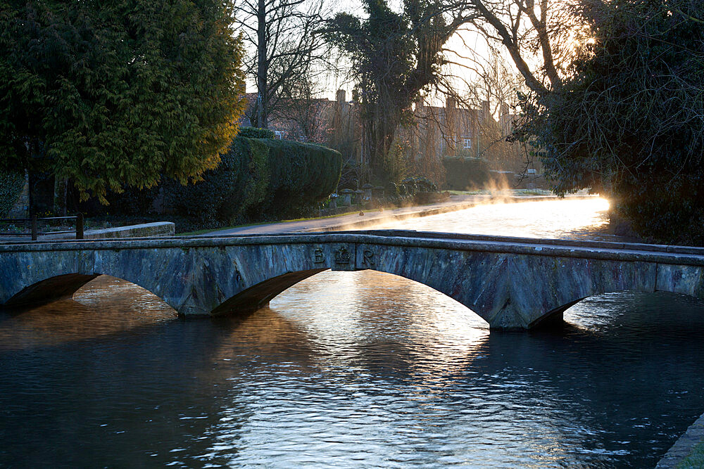 Cotswold stone bridge over River Windrush in mist, Bourton-on-the-Water, Cotswolds, Gloucestershire, England, United Kingdom, Europe