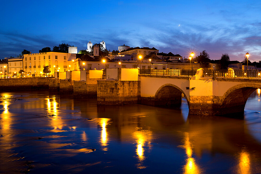 Seven arched Roman bridge and town on the Rio Gilao river at night, Tavira, Algarve, Portugal, Europe