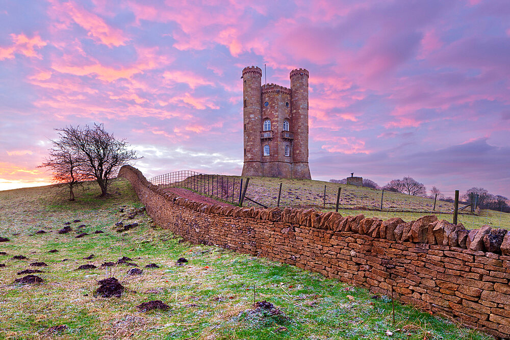 Broadway Tower and Cotswold drystone wall at sunrise, Broadway, Cotswolds, Worcestershire, England, United Kingdom, Europe