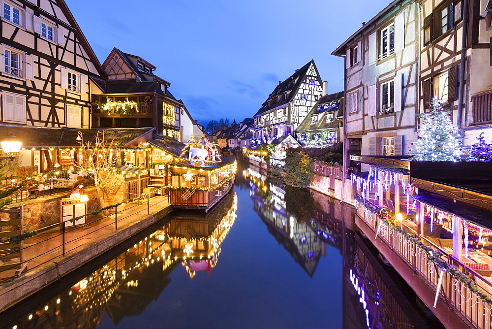 Christmas decorations on old buildings along La Lauch river in the Little Venice area at night, Colmar, Alsace, France, Europe