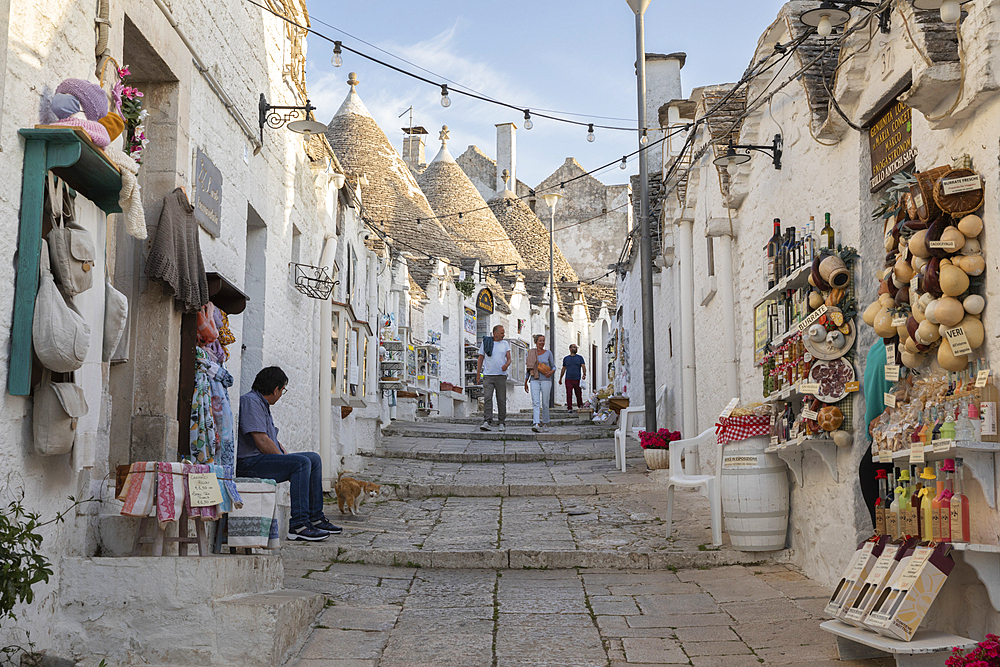 Whitewashed trulli houses and souvenir shops along street in the old town, Alberobello, Puglia, Italy, Europe