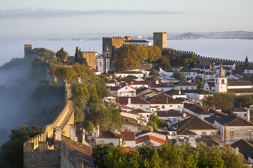 View over the old town and walls of Obidos in morning mist, Obidos, Centro Region, Estremadura, Portugal, Europe