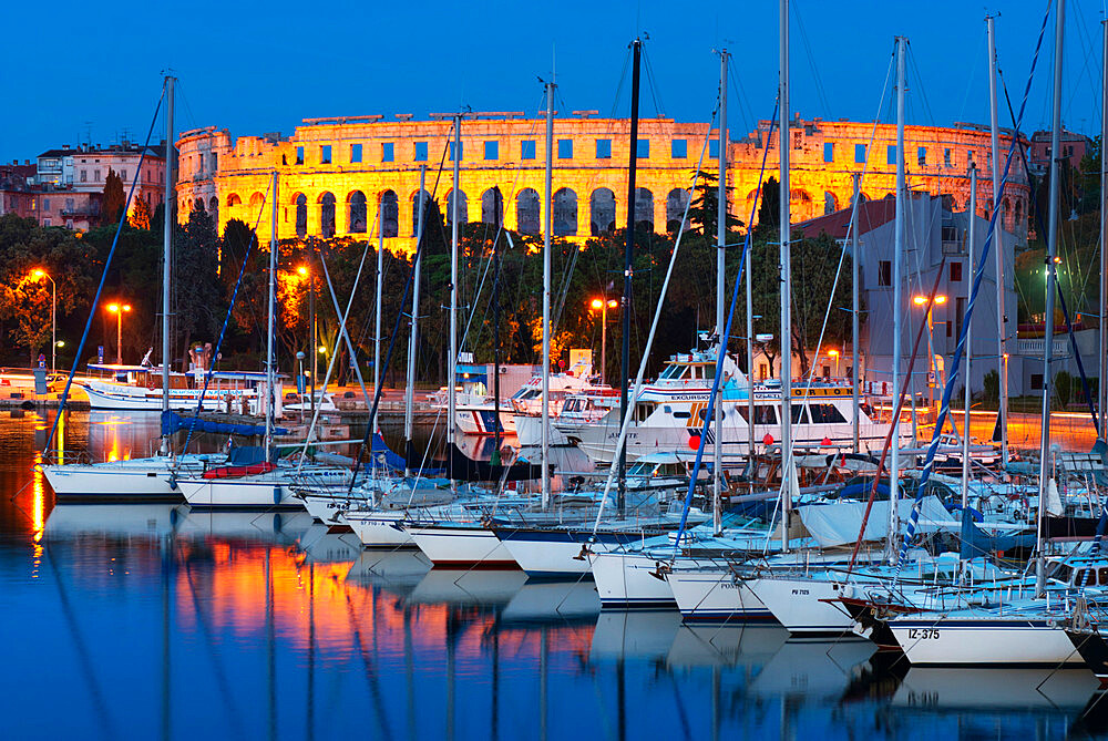 Dusk over marina and the Roman Amphitheatre, Pula, Istria, Croatia, Adriatic, Europe