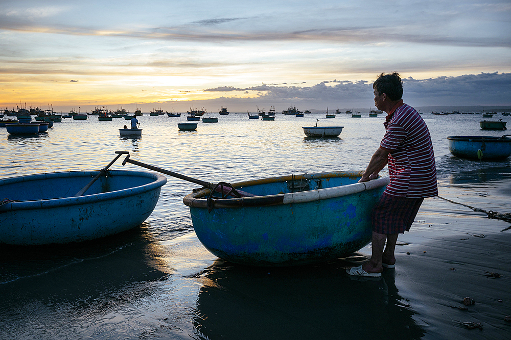 Man pulling boat in to shore, Fishing Village, Mũi Né, Bình Thuận Province, Vietnam